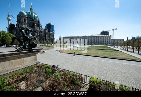 21 avril 2020, Berlin: Une femme traverse le jardin de loisirs vide entre le musée Altes et la cathédrale de Berlin sur l'île des musées. Les 170 musées d'État, municipaux et privés de Berlin sont fermés depuis la mi-mars. L'île des musées du centre de Berlin, qui a été désignée site du patrimoine mondial, a été visitée pour la dernière fois par trois millions de personnes chaque année. Sous réserve que les maisons respectives soient en mesure de satisfaire aux exigences d'hygiène et aux réglementations sur la distance en vigueur pendant la crise de Corona, le Sénat de Berlin envisage de rouvrir les musées le 11 mai 202 Banque D'Images