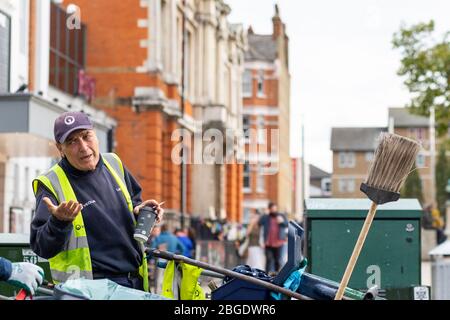 Un nettoyeur de rue dans une veste haute visibilité debout à Windrush Square, Brixton, Londres Banque D'Images