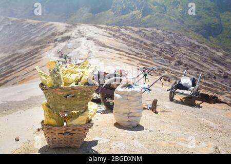 Panier porte-soufre à Kawah Ijen, Indonésie. Panier lourd chargé de morceaux de soufre naturel à transporter par les mineurs de la mine de cratère. Opération manuelle d'extraction intensive de soufre dans le volcan Kawah Ijen. Banque D'Images