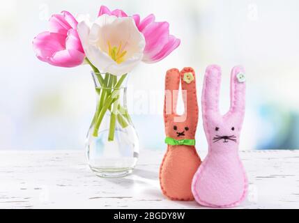 De belles tulipes dans un seau dans un vase sur une table sur fond clair Banque D'Images