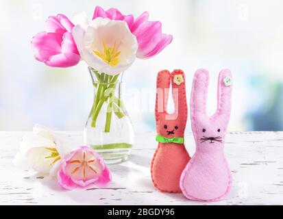 De belles tulipes dans un seau dans un vase sur une table sur fond clair Banque D'Images