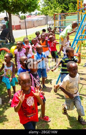 Soweto, Afrique du Sud - 16 novembre 2012: Jeunes enfants d'Afrique préscolaire jouant dans le terrain de jeux d'une école de maternelle Banque D'Images