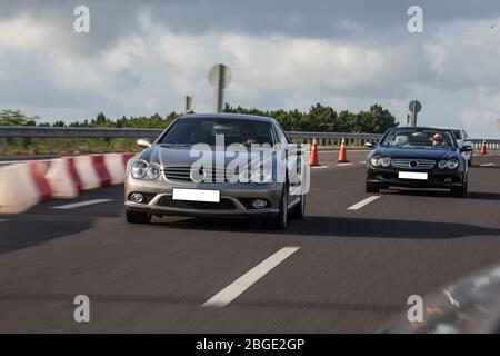 Cabriolet noir se faisant visiter sur l'autoroute en une journée de sueur chaud, chassant d'autres voitures Banque D'Images