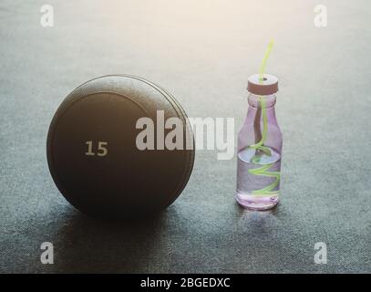 Gros plan sur la boule de slamball de 15 kg et la bouteille d'eau avec espace de copie. Concept de sport et de loisirs. Banque D'Images