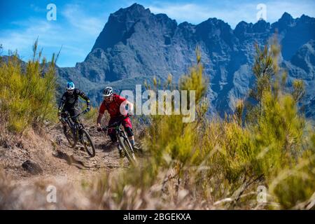 Deux hommes pédalent sur un sentier près de la ville de Cilaos sur l'île de la Réunion dans l'océan Indien. Banque D'Images