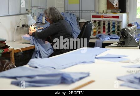 Un membre de la salle de travail Hursley près de Winchester cousu ensemble des morceaux de gommages. Deborah Philbrow, designer d'intérieur, a mis en place une équipe de bénévoles pour coudre des centaines de jeux de gommages pour les médecins et le personnel de soins à domicile de première ligne qui ont besoin d'un équipement de protection individuelle (EPI). Banque D'Images