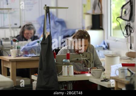 Un membre de la salle de travail Hursley près de Winchester cousu ensemble des morceaux de gommages. Deborah Philbrow, designer d'intérieur, a mis en place une équipe de bénévoles pour coudre des centaines de jeux de gommages pour les médecins et le personnel de soins à domicile de première ligne qui ont besoin d'un équipement de protection individuelle (EPI). Banque D'Images