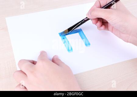 Enfant dessine la maison avec des aquarelles, gros plan Banque D'Images