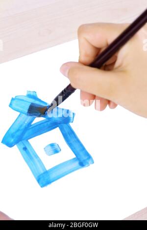 Enfant dessine la maison avec des aquarelles, gros plan Banque D'Images