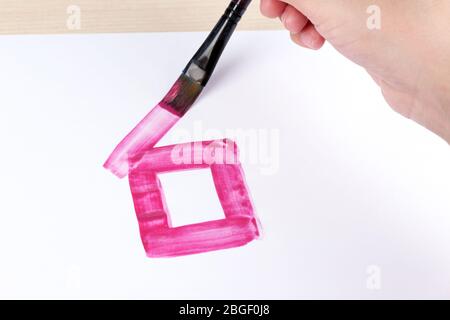 Enfant dessine la maison avec des aquarelles, gros plan Banque D'Images