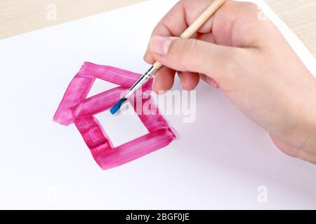 Enfant dessine la maison avec des aquarelles, gros plan Banque D'Images