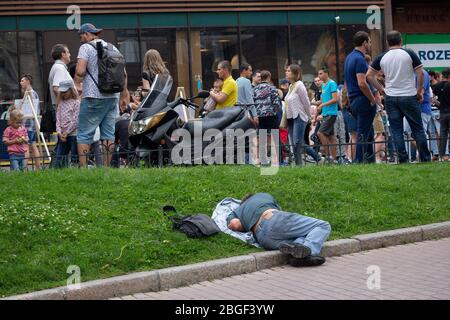 Kiev, Ukraine - 09 juillet 2017: Homme dormant sur la pelouse sur la rue Khreshchatyk Banque D'Images