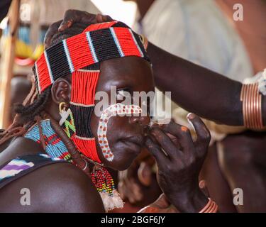 Les tribéshommes de Hamer appliquent de la peinture faciale avant le début d'une cérémonie tribale. Photographié dans la vallée de la rivière Omo, en Ethiopie Banque D'Images