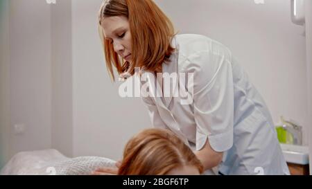 Massage - maître de massage au gingembre donnant un massage à une jeune femme dans l'armoire - intérieur Banque D'Images