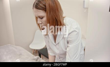 Massage - jeune maître de massage au gingembre donnant un massage à une jeune femme dans l'armoire - intérieur Banque D'Images