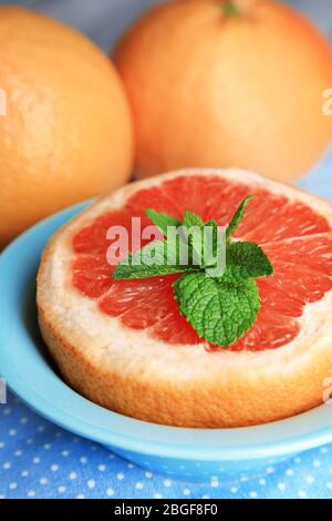 Grapefruits mûrs dans un bol sur fond en bois couleur Banque D'Images