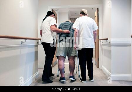 Le personnel aide un homme à utiliser un cadre de zimmer dans un foyer de soins résidentiels à Redcar, au Royaume-Uni. 2/2/2018. Photo: Stuart Bolton. Banque D'Images