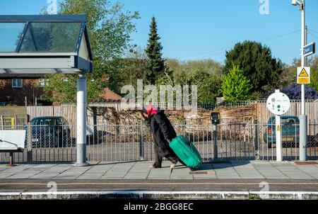 Datchet, Berkshire, Royaume-Uni. 21 avril 2020. Une dame qui a le sommeil difficile a du mal à tirer ses possesions derrière elle dans les cas à la station de Datchet pendant la pandémie de coronavirus. Crédit : Maureen McLean/Alay Banque D'Images