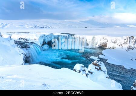 La rivière islandaise à moitié gelée Skjalfandafljot qui coule au-dessus de la cascade Godafoss en hiver. Toujours très fluide mais neige couverte et avec de grandes iciques Banque D'Images