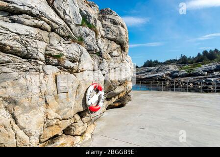 Une bouée de sauvetage à côté d'une plaque d'information métallique à la piscine publique de mer de Sjobadet Myklebust à Tananger, Norvège, mai 2018 Banque D'Images