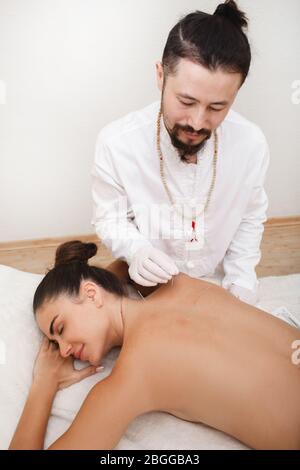 Réflexologue faisant une procédure d'acupuncture. Soulagement du stress avec acupuncture. Médecine chinoise traditionnelle Banque D'Images