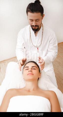 Chiropraticien faisant un massage de tête énergique. Femme obtenant la thérapie de reiki. Médecine alternative Banque D'Images