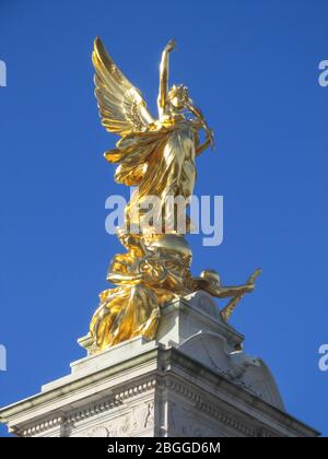 La statue dorée au-dessus du Mémorial de Victoria, juste à l'extérieur du palais de Buckingham, à Londres, au Royaume-Uni, lors d'une journée ensoleillée avec un ciel bleu vif Banque D'Images