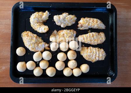 poulet pané congelé et petites boules de pommes de terre fritures avant la cuisson Banque D'Images