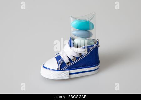 Mini-sneaker bleue avec bonbons aux amandes sugouis dans un fond gris isolé de près Banque D'Images