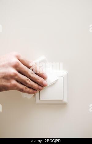 Mains mâles avec un spray désinfectant désinfectez la surface de l'interrupteur dans la maison. Covid-19 pandémie de quarantaine du coronavirus. Isolement à la maison. Protec Banque D'Images