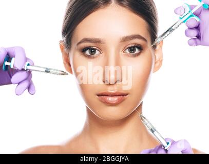 Concept publicitaire femme de peau de levage à l'aide d'injection de beauté sur iasolated blanc. Beaucoup de seringues autour d'un visage de femme. non chirurgicale, de cosmétologie Banque D'Images