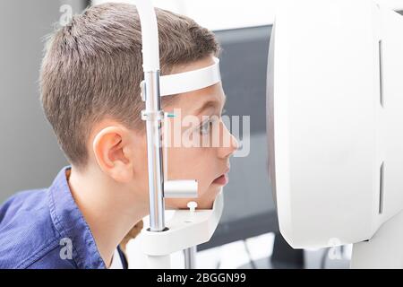 Correction de la vision dans un garçon. Face rapprochée du garçon du patient. Équipement super moderne dans une clinique moderne pour l'examen des yeux Banque D'Images