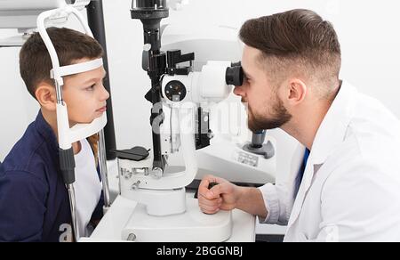 L'ophtalmologiste mâle vérifie la vue d'un adolescent avec un équipement ophtalmique spécial. Garçon a très bonne vue Banque D'Images