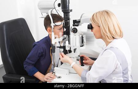 Optométriste examine le garçon d'un patient avec un équipement ophtalmique spécial dans une clinique moderne. Correction de la vision chez les enfants Banque D'Images