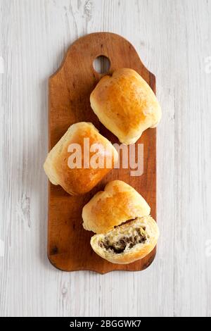 Bœuf maison Bierocks russes sur une planche en bois rustique, vue sur le dessus. Couche plate, en hauteur, par dessus. Banque D'Images