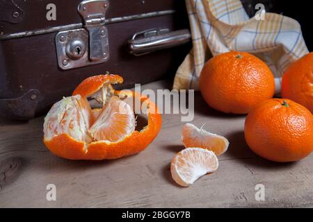 Plusieurs mandarines ou oranges, tangerines, clémentines, agrumes, un fruit est à moitié pelé et des tranches d'homme pelé Banque D'Images