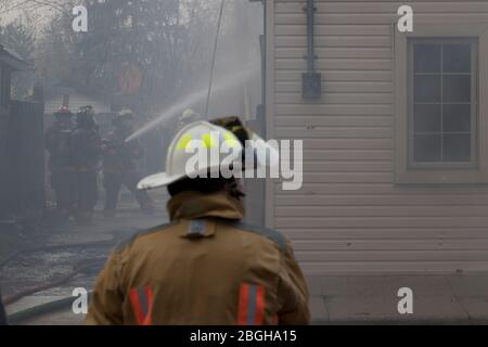 Les pompiers qui combattent le feu ont commencé par un incendie criminel. Contenir la propagation du feu de maison résidentielle. Banque D'Images