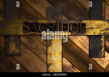 Photo de véritables lettres de composition authentiques formant du texte sacrifice sur fond de cuivre et d'or texturé vintage Banque D'Images