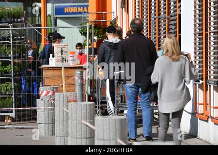 Munich. 21 avril 2020. Exigences de masque en Bavière dans tous les magasins et dans les transports publics locaux. Ouverture de magasins de matériel le 21 avril 2020 à Munich. Les clients sont en ligne devant un magasin de matériel OBI. | utilisation dans le monde crédit: dpa/Alay Live News Banque D'Images