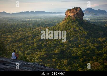 Un touriste envisage le lever du soleil au Sigiriya Rock, Sri Lanka, du Pidurangala Rock. Le Sigiriya Rock est une attraction touristique populaire, un monde de l'UNESCO Banque D'Images