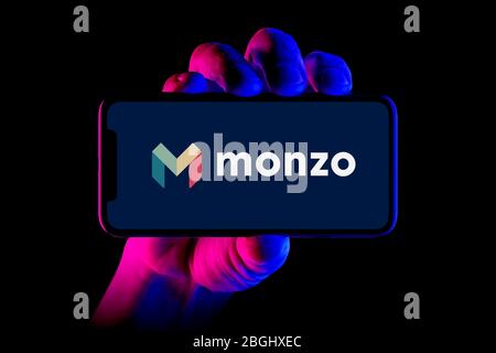 Un smartphone affichant le logo Monzo Bank est placé sur un fond noir (usage éditorial uniquement). Banque D'Images