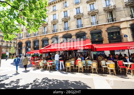Les Parisiens et les touristes apprécient les boissons de la journée d'été dans le café à la visière rouge, le trottoir de Paris Banque D'Images