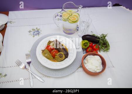 Les aubergines sont farcies d'agneau à la viande et de riz. Plican . remplissage de l'aubergine . Aubergine, poivrons, tomates . Yaourt dans un bol marron . Citron haché dans un Banque D'Images