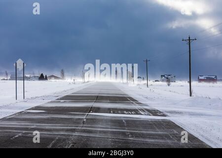 Neige qui souffle sur la neige à travers la route près de Rudyard dans la partie orientale de la péninsule Haute, Michigan, États-Unis [pas de libération de propriété; disponible pour licence éditoriale Banque D'Images