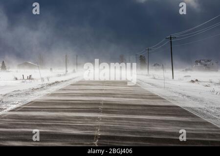 Neige qui souffle sur la neige à travers la route près de Rudyard dans la partie orientale de la péninsule Haute, Michigan, États-Unis [pas de libération de propriété; disponible pour licence éditoriale Banque D'Images