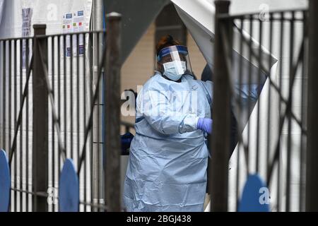 New York City, États-Unis. 21 avril 2020. Un professionnel de la santé portant un équipement de protection personnelle tire un rabat de tente lorsqu'il appelle à renvoyer une personne attendant d'être testée pour COVID-19 dans les hôpitaux sanitaires/Gotham Health de Harlem, Sydenham, à New York, NY, le 21 avril 2020. Le Coronavirus a eu un impact disproportionné sur les communautés africaines américaines. (Anthony Behar/Sipa USA) crédit: SIPA USA/Alay Live News Banque D'Images