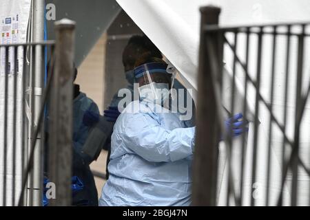 New York City, États-Unis. 21 avril 2020. Un professionnel de la santé portant un équipement de protection personnelle tire un rabat de tente lorsqu'il appelle à renvoyer une personne attendant d'être testée pour COVID-19 dans les hôpitaux sanitaires/Gotham Health de Harlem, Sydenham, à New York, NY, le 21 avril 2020. Le Coronavirus a eu un impact disproportionné sur les communautés africaines américaines. (Anthony Behar/Sipa USA) crédit: SIPA USA/Alay Live News Banque D'Images