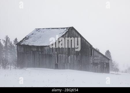 Grange avec neige soufflée lors d'une journée d'hiver dans l'est de la péninsule Haute, Michigan, États-Unis [pas de mainlevée de propriété; disponible pour licence éditoriale seulement] Banque D'Images