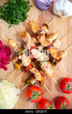 Ensemble de Shish Kebabs . kebab de boeuf sur une planche en bois . Sauerkraut de chou rouge . purée de pommes de terre . Ail, oignon, tomates. Coriandre hachée . Agneau Banque D'Images