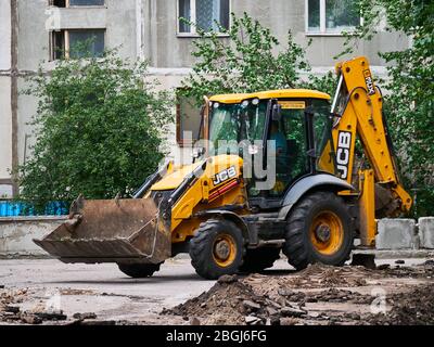 KHARKOV, UKRAINE - MARS 2020, Pelle hydraulique retirer les restes d'asphalte. Reconstruction de routes. Réparation de la chaussée Banque D'Images